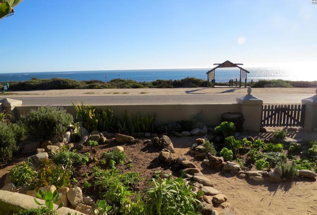 a garden in front of a beach with a gazebo at Polka & Nollies in Port Nolloth
