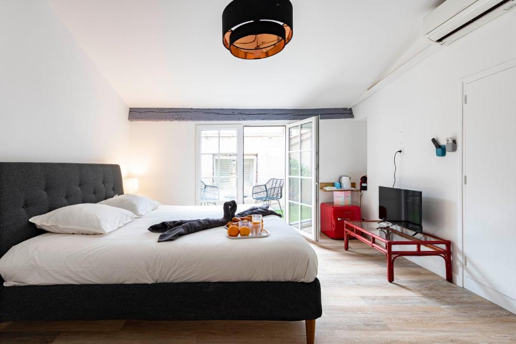 a bedroom with a large bed and a television at Villa Sibille - Plein centre de Saint-Tropez in Saint-Tropez