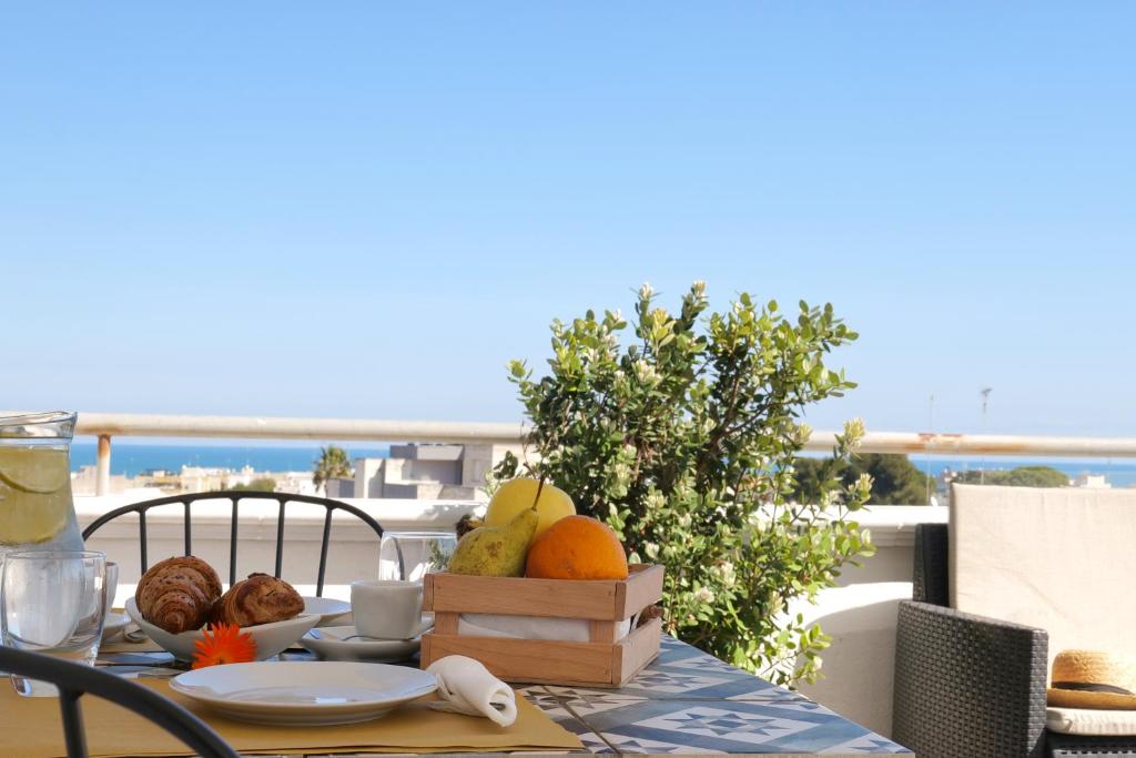a table with a plate of fruit on a balcony at Bed&Belvedere in Otranto