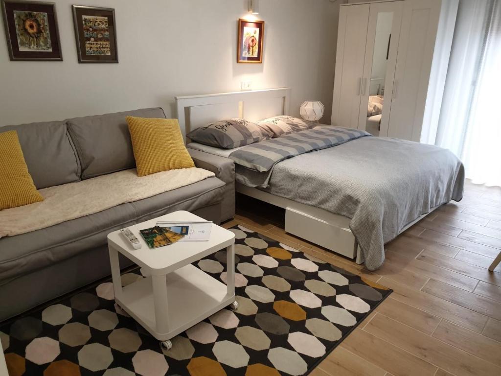 a living room with a couch and a bed and a table at Apartments Ziher in Zagreb