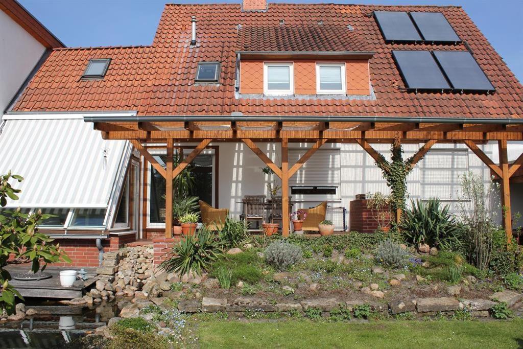 a house with a wooden pergola in a yard at Pauls, Ferienwohnung in Celle