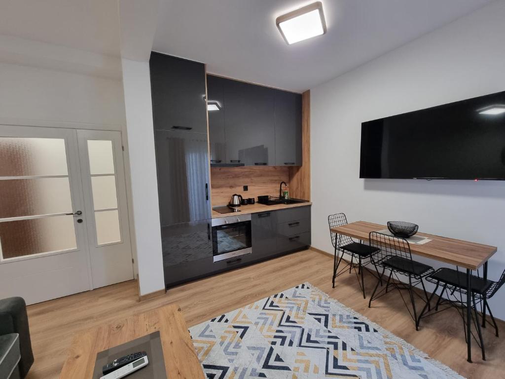 a living room with a table and a kitchen at Dom B Apartments in Budva