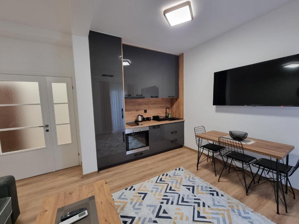 uma sala de estar com uma mesa e uma cozinha em Dom B Apartments em Budva