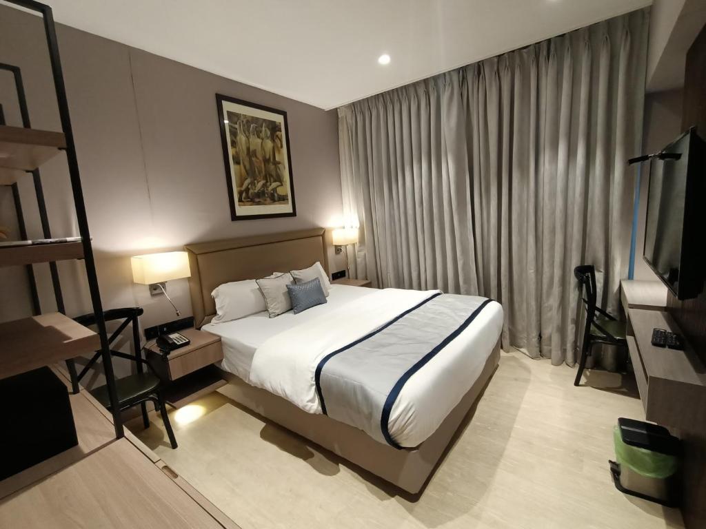 a hotel room with a bed and a television at Hotel Highway Inn Andheri East in Mumbai