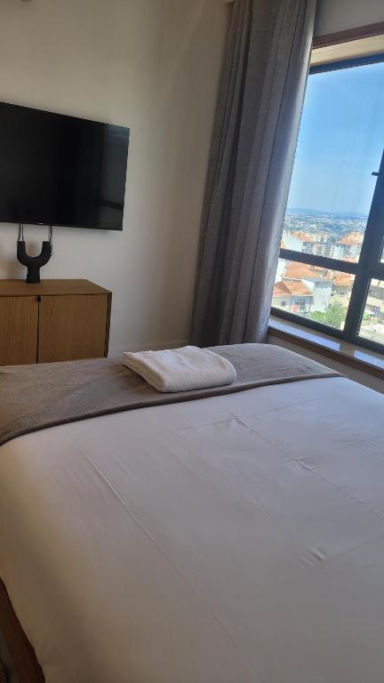 sypialnia z dużym łóżkiem i dużym oknem w obiekcie Studio Oporto (Gaia) w mieście Vila Nova de Gaia