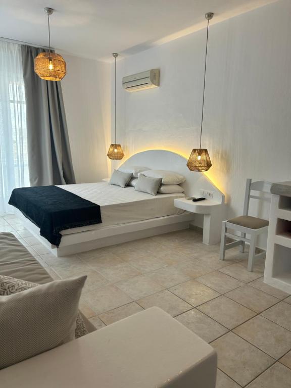 een slaapkamer met een bed, een stoel en verlichting bij Apollonia Studios in Plaka