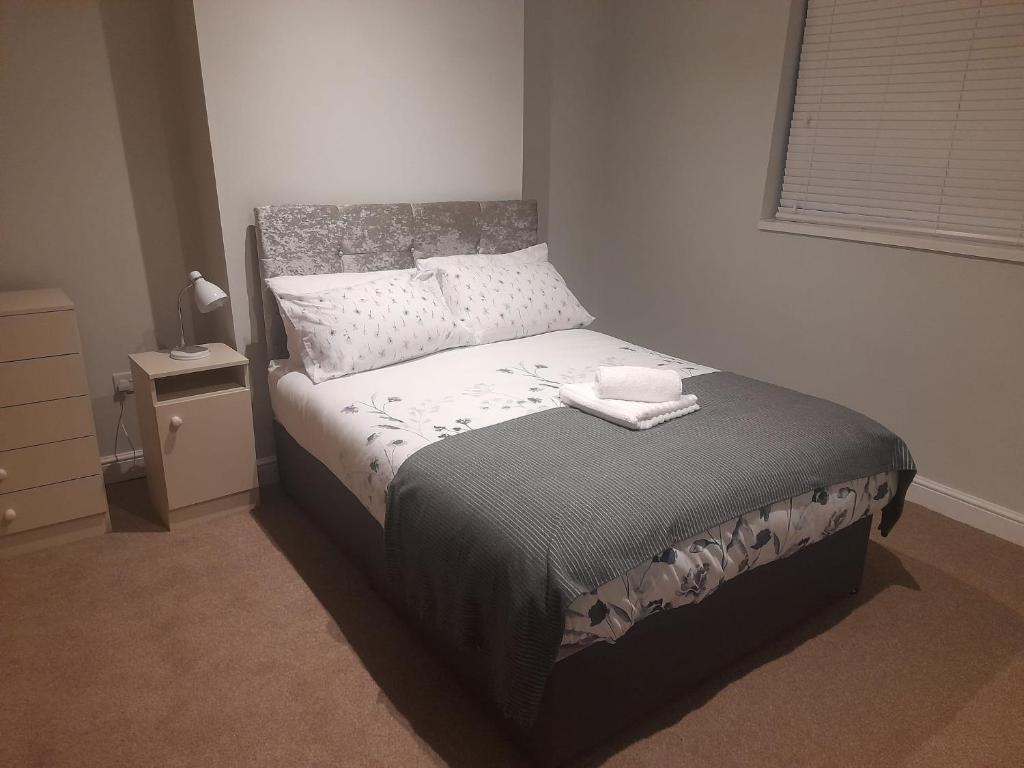 a bedroom with a bed in a room with a window at Chorlton Apartments in Sale