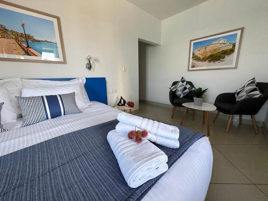 a bedroom with a bed with towels on it at The Beach House in Birżebbuġa