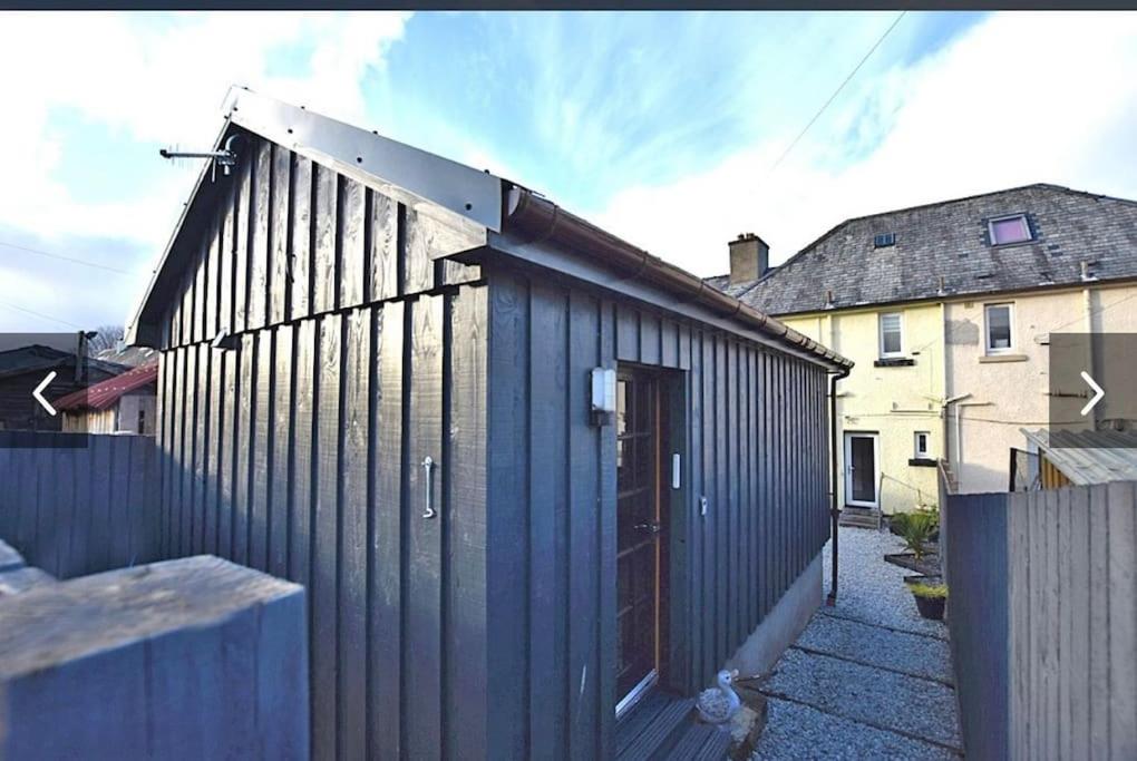 un edificio blu con una porta e una recinzione di Taigh Beag a Inverlochy