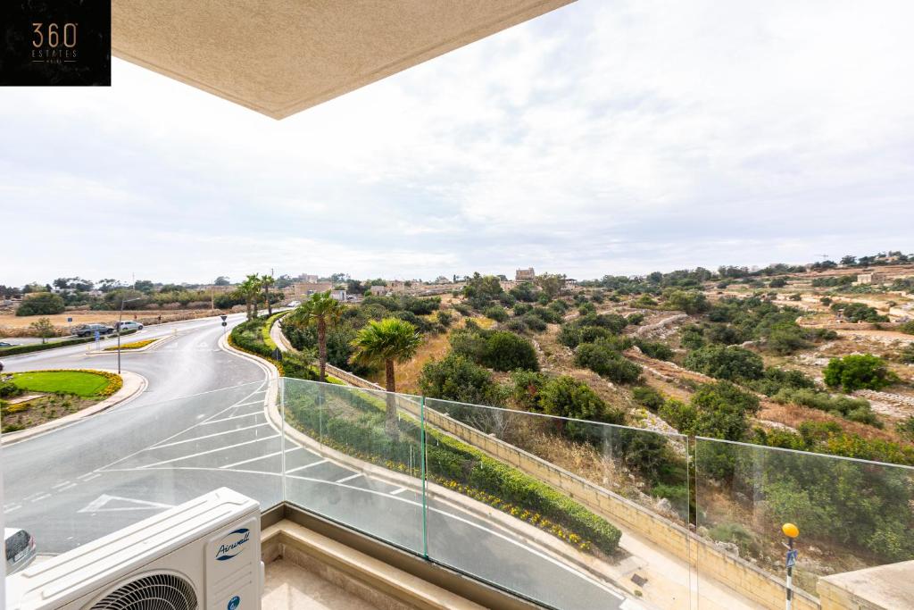 einen Blick vom Balkon eines Hauses mit einer Straße in der Unterkunft Beautiful 2BR APT with beautiful w/tranquil views by 360 Estates in Marsaxlokk