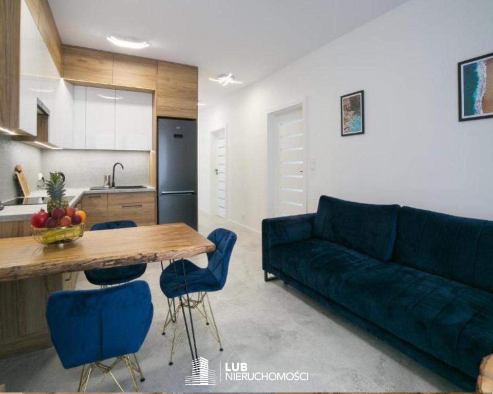 een woonkamer met een blauwe bank en een tafel bij Oxygen apartament nr 1 in Mielec