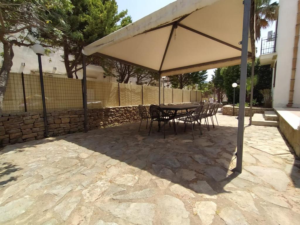 a table and chairs under an umbrella on a patio at SanVitoTour- Residence Il Baglio in San Vito lo Capo