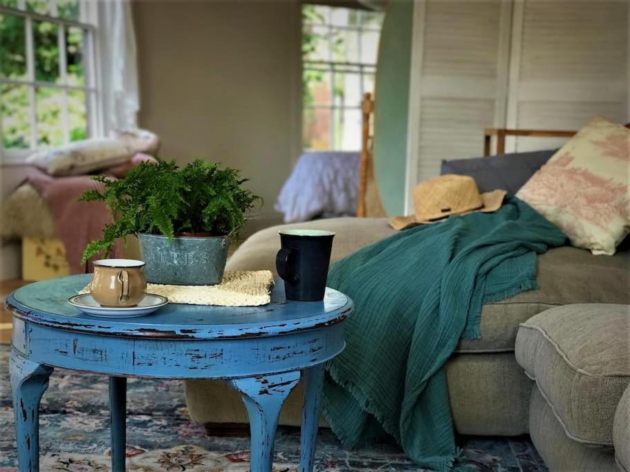 a living room with a blue table and a couch at Historic school room in Helston