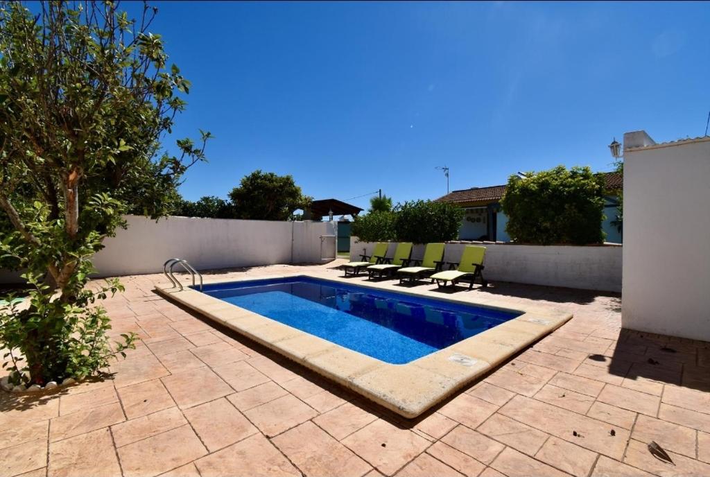 uma piscina num pátio com cadeiras à volta em Chalet La Alberca em Chiclana de la Frontera