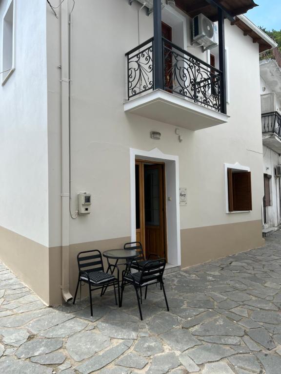 patio z krzesłami i stołem oraz balkonem w obiekcie Lagom House w mieście Panagia