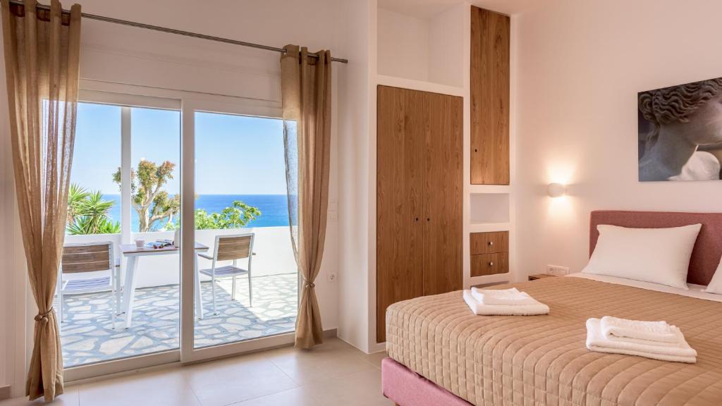 a bedroom with a bed and a view of the ocean at Giourgas Studios & Apartments in Provatas