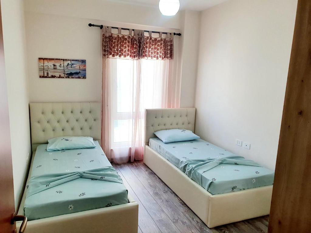 Кровать или кровати в номере Apartament me qera Lungomare Vlore Mari