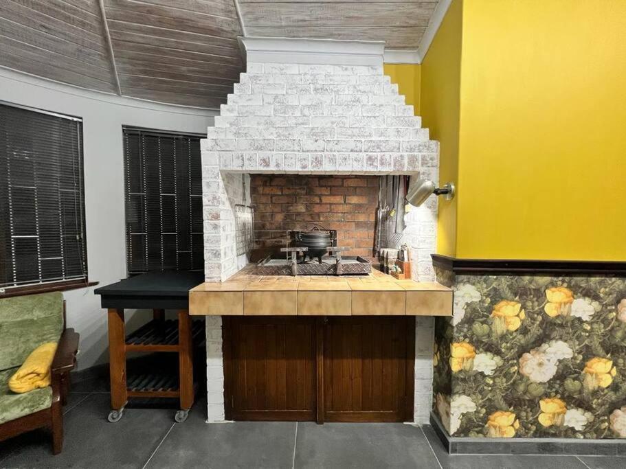Il comprend une cuisine équipée d'une cuisinière et d'une cheminée en briques. dans l'établissement Seaview Family Cottage, à Swakopmund