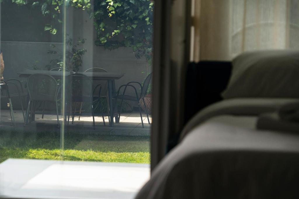 a view of a patio with a table and chairs through a window at Edem Luxury Apartments in Nea Peramos