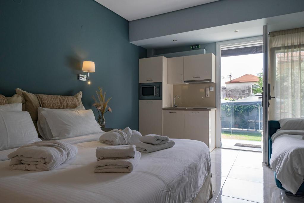 a bedroom with a white bed with towels on it at Edem Luxury Apartments in Nea Peramos