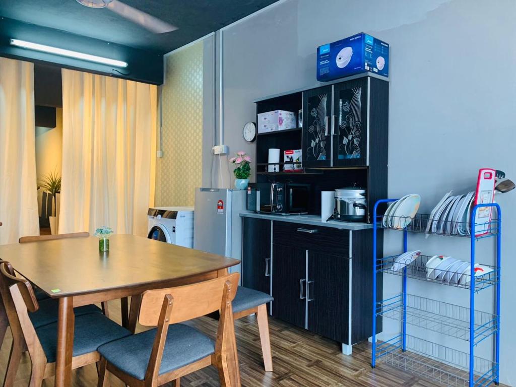 Il comprend une cuisine et une salle à manger avec une table et un réfrigérateur. dans l'établissement Homestay Dizaherbs KT, à Kuala Terengganu