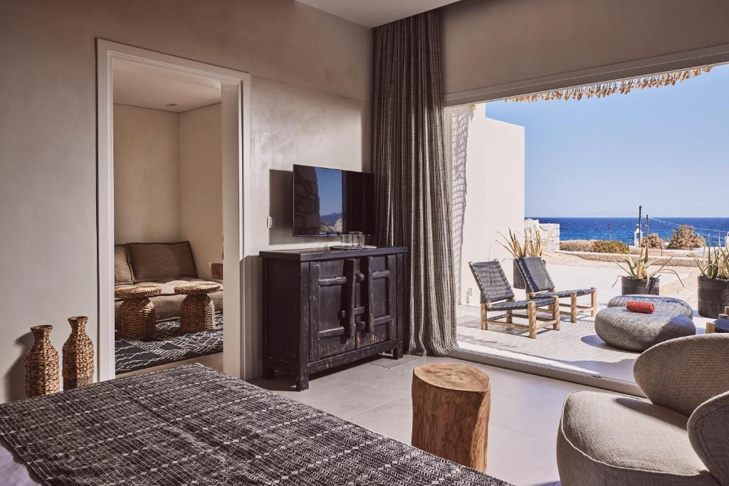 una camera con letto, TV e patio di Serenity Suite Milos a Mandrakia