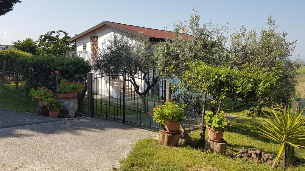 ein Haus mit einem Tor mit Topfpflanzen darauf in der Unterkunft Villa con Biolago - Downstairs in Cappelle sul Tavo