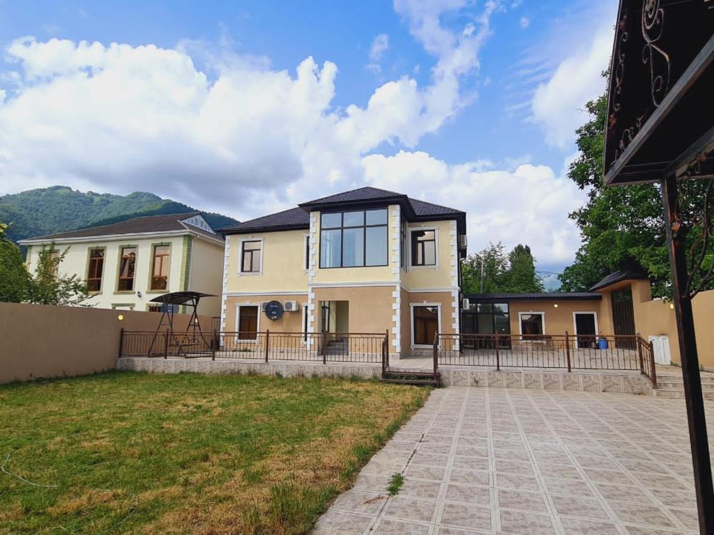 a large house with a driveway in front of it at Villa Qebele in Küsnǝt