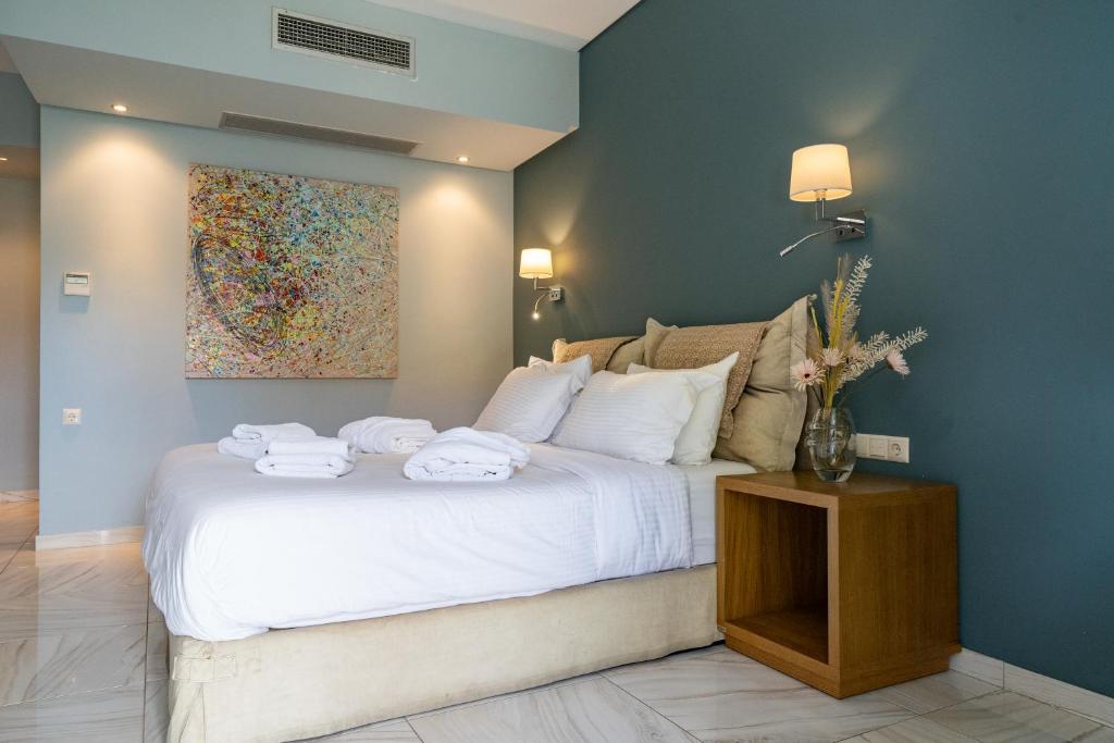 a bedroom with a white bed with towels on it at Edem Luxury Apartments in Nea Peramos