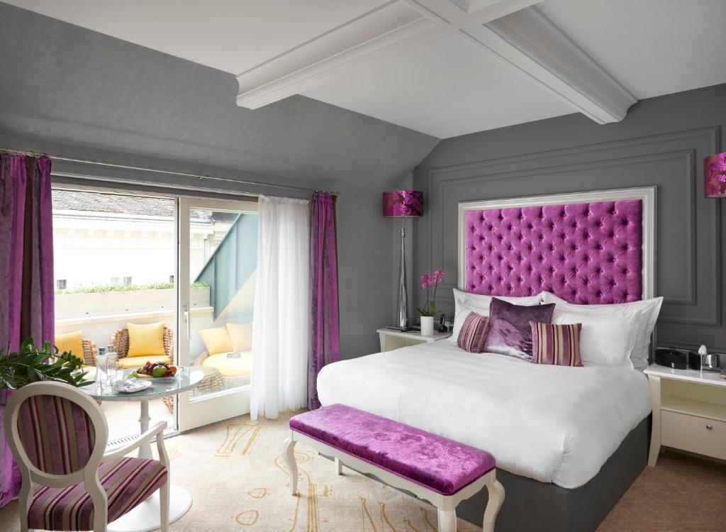 a bedroom with a large bed with a purple headboard at Aria Hotel Budapest by Library Hotel Collection in Budapest