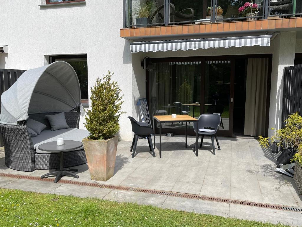 a patio with a table and chairs and a couch at Ferienwohnung Gorch-Fock Scharbeutz in Scharbeutz