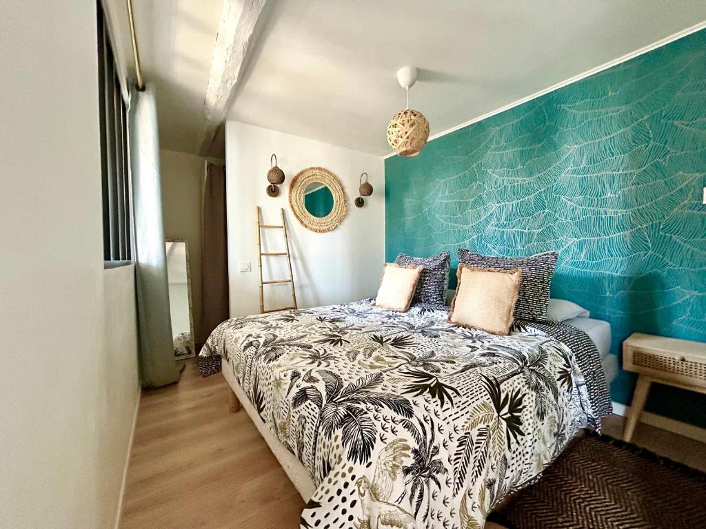 1 dormitorio con 1 cama con pared azul en Rue Marceau Cogolin, en Cogolin