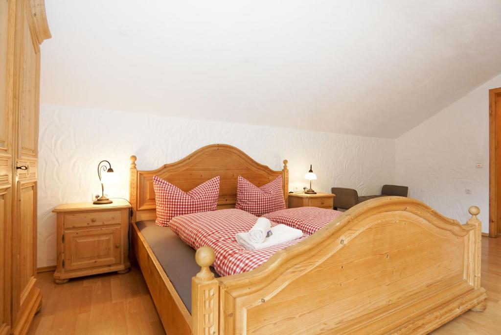 una camera con letto in legno e cuscini rosa di Feriengut zum Fürst´n a Eppenschlag