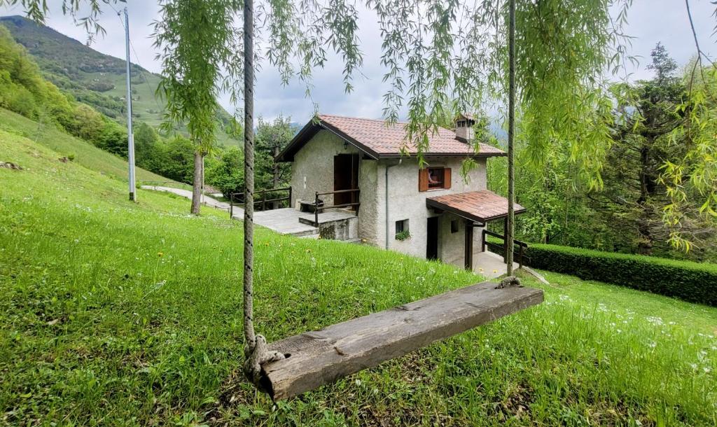 una pequeña casa en una colina con un columpio en Charming Mountain Hut on Grigna Mountain - Como Lake, en Pasturo