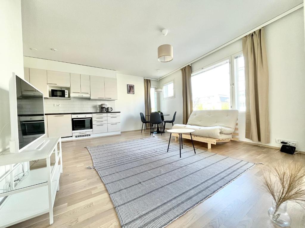 uma cozinha e sala de estar com um sofá e uma mesa em Tammer Huoneistot - City Suite 5 - Own Sauna, Balcony & Best Location em Tampere