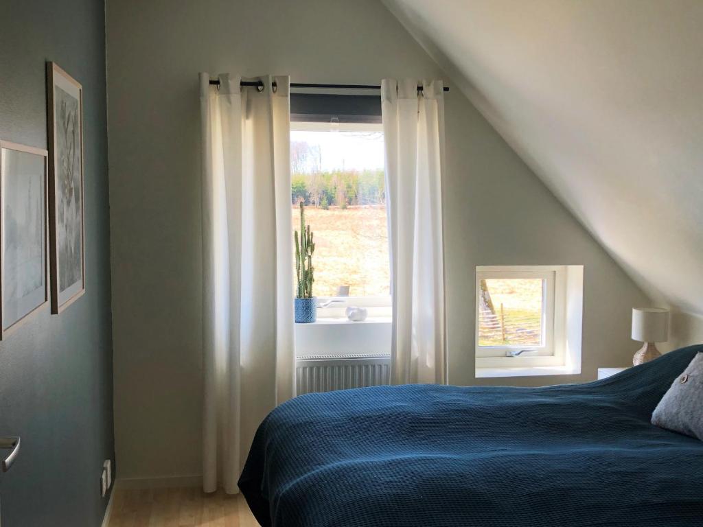a bedroom with a bed and a window at Nice apartment outside Laholm in rural idyll in Laholm