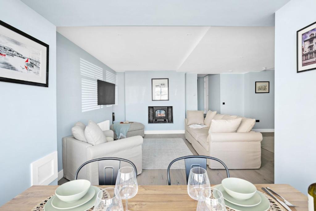 a white living room with a table and chairs at Mayflower, Maritime Suites in Brixham