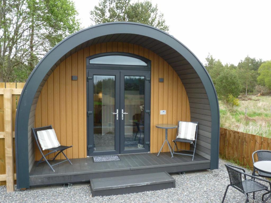 einen Pavillon mit 2 Stühlen und einem Tisch in der Unterkunft Tanleys - Skye Pod in Grantown on Spey