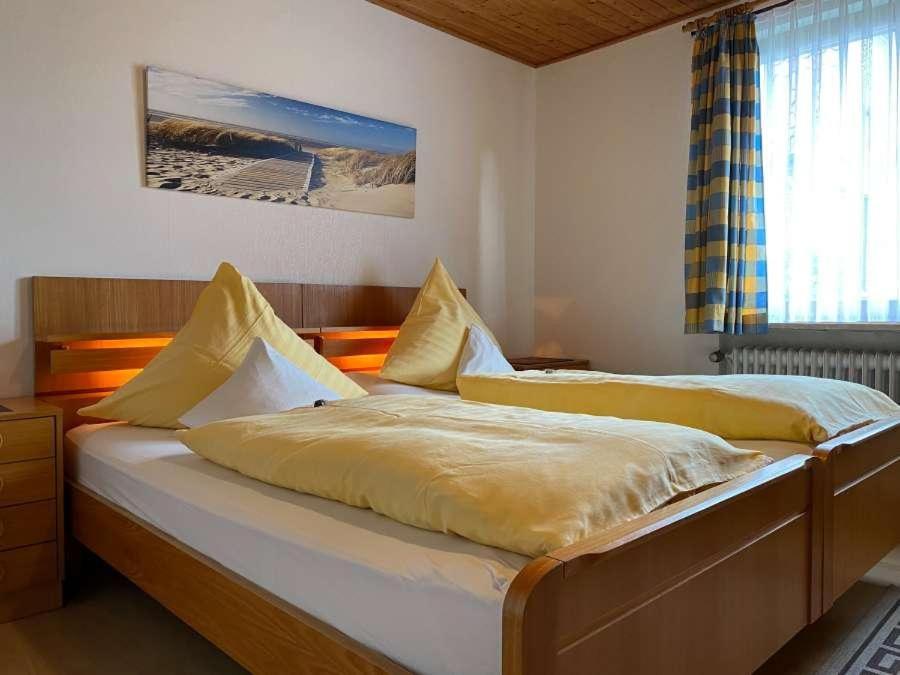 1 dormitorio con 2 camas con sábanas amarillas y ventana en Ferienwohnung Bädke en Müden