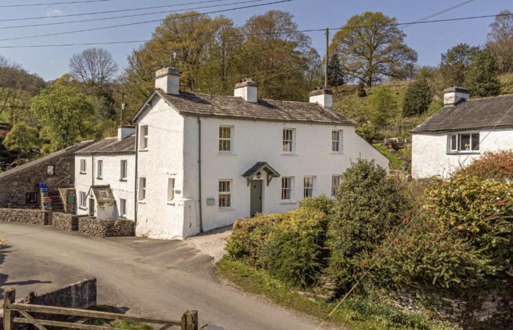 a white house on the side of a road at Woodside Cottage - Cartmel Fell, Windermere in Windermere