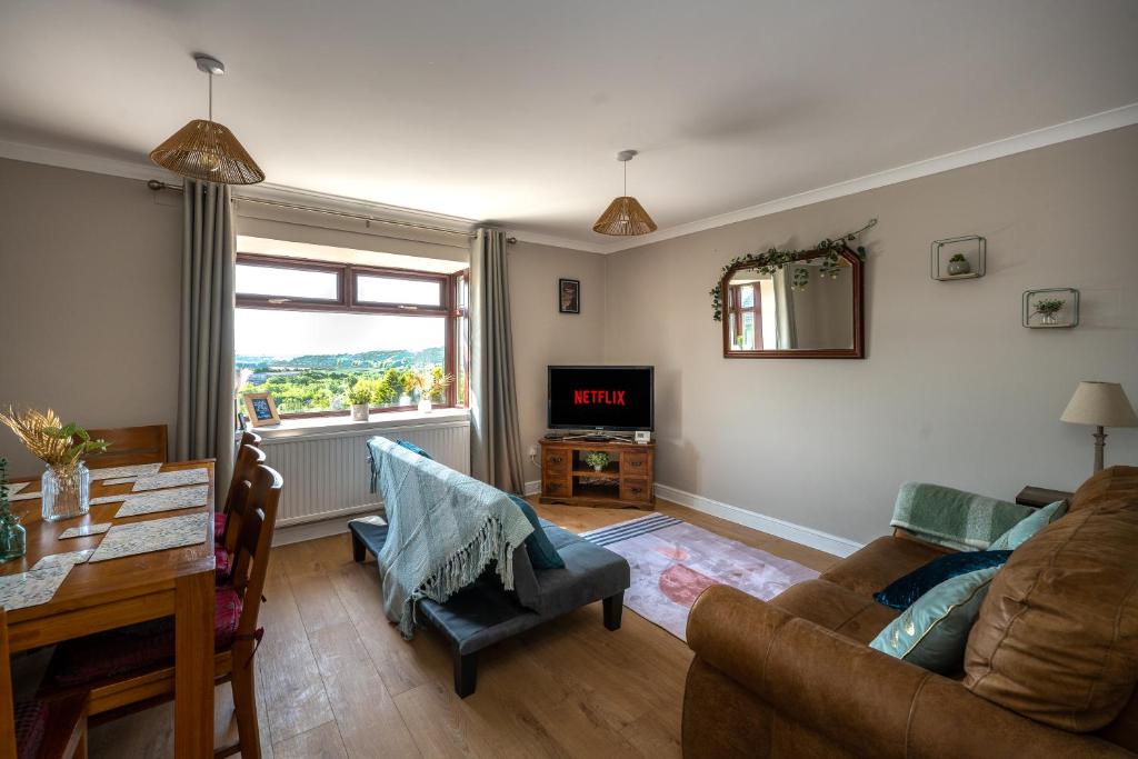 a living room with a couch and a table at Charming 2-Bed Home in Neath in Skewen