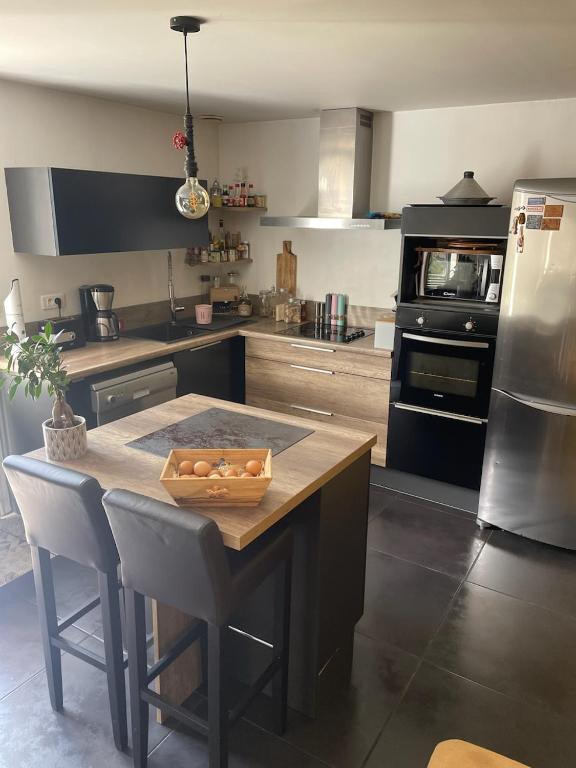 a kitchen with a table with a bowl of food on it at Maison Mimosa in Saumur