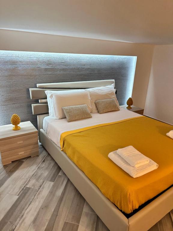 a bedroom with a large bed with yellow sheets at Sanduli Luxury House in Agrigento