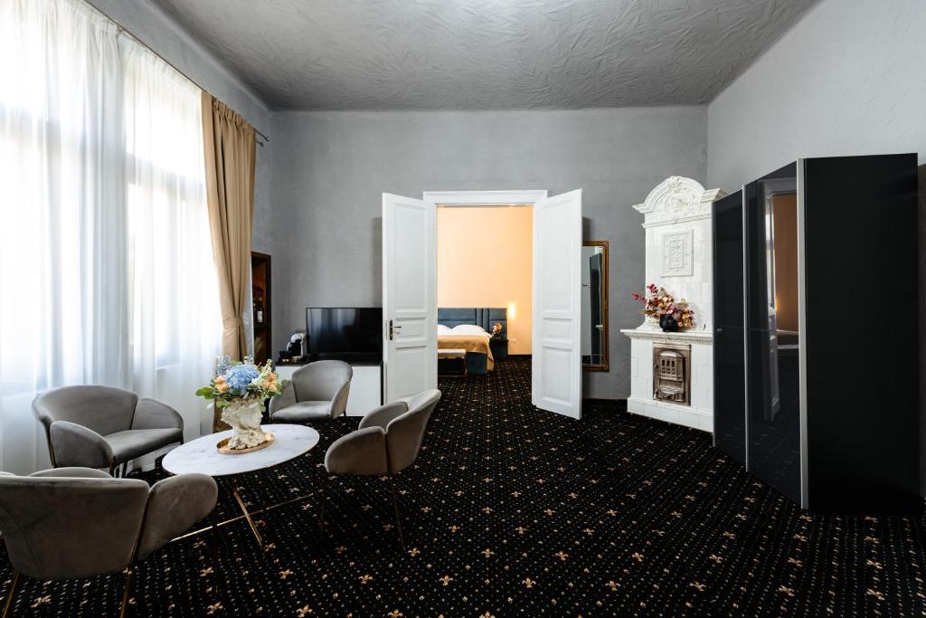 ein Zimmer mit Stühlen und ein Zimmer mit einem Schlafzimmer in der Unterkunft Palace Bulevard Inn in Cluj-Napoca