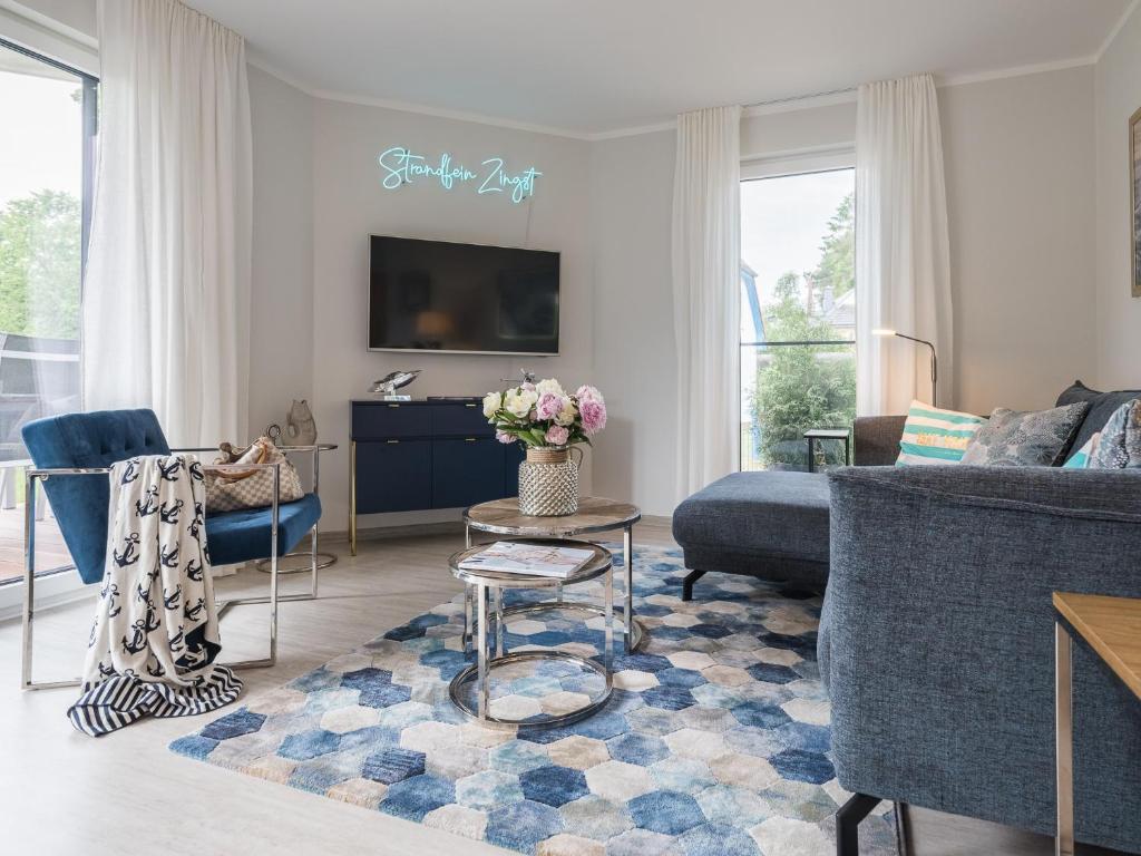 a living room with a couch and a tv at Villa Baltic Zingst - AP Strandfein in Zingst