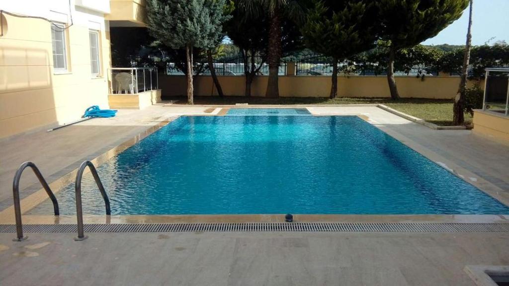 a large blue swimming pool next to a house at SunSet Apartments 4,5,6 in Belek