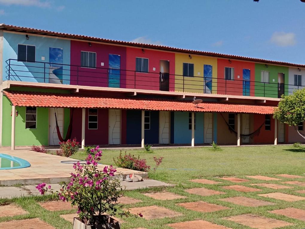 a building with colorful doors and balconies on it at Pousada Rota das Dunas de Amaro in Santo Amaro