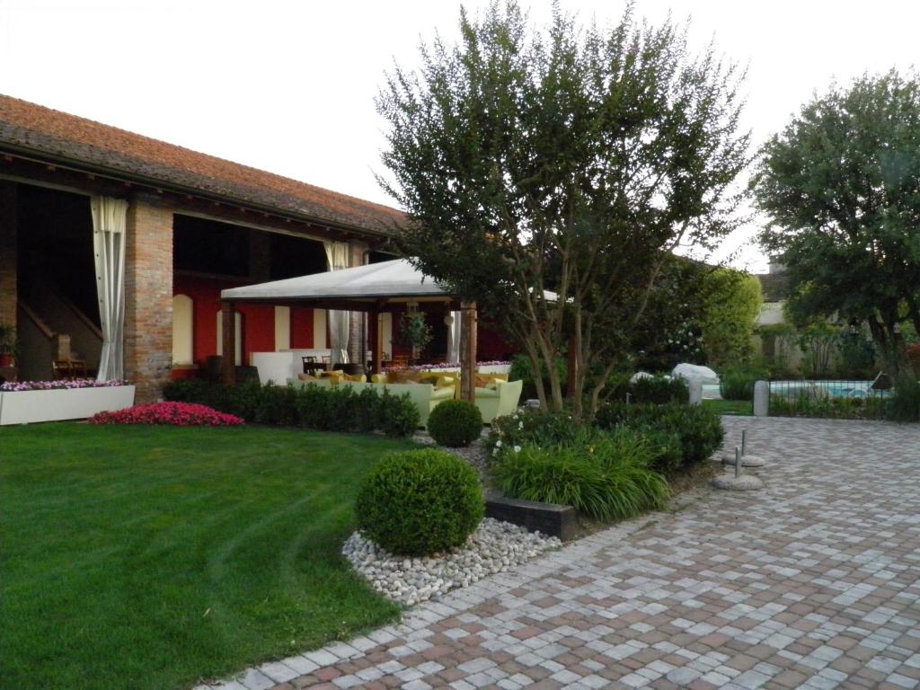 Cornaleto的住宿－Affittacamere Il Persicone，一座带砖砌走道的花园的房子