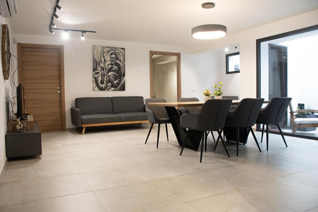 sala de estar con mesa, sillas y sofá en Domus Alba Apartment, en Trapani