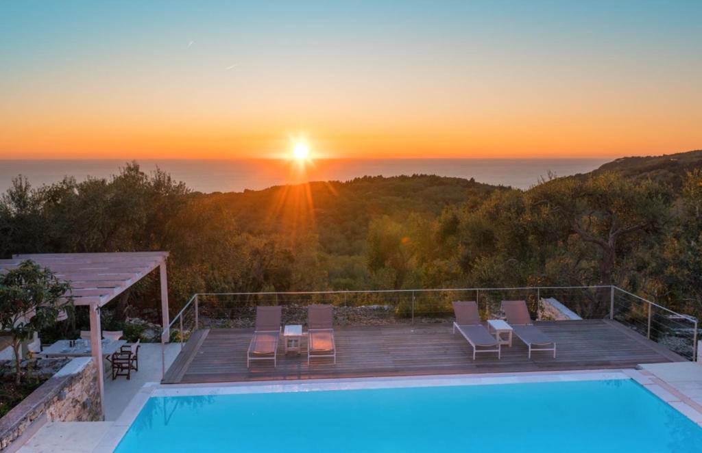 une villa avec une piscine et un coucher de soleil dans l'établissement Kallista House, à Kourtaíïka